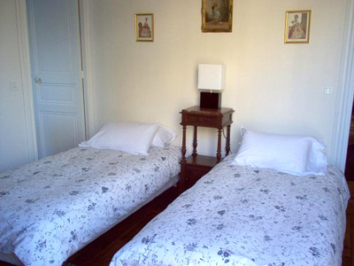 The second bedroom is bright and sunny with large windows. It has two firm twin beds.